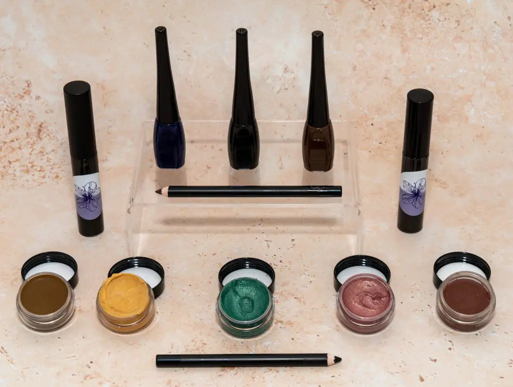 Colorful makeup collection with eyeliner and eyeshadow pots.