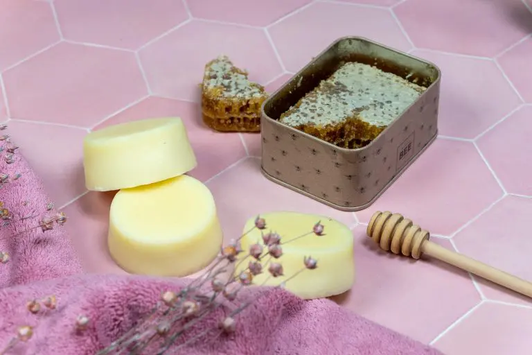 Conditioner bar, Honeycomb and wax chunks on pink surface.
