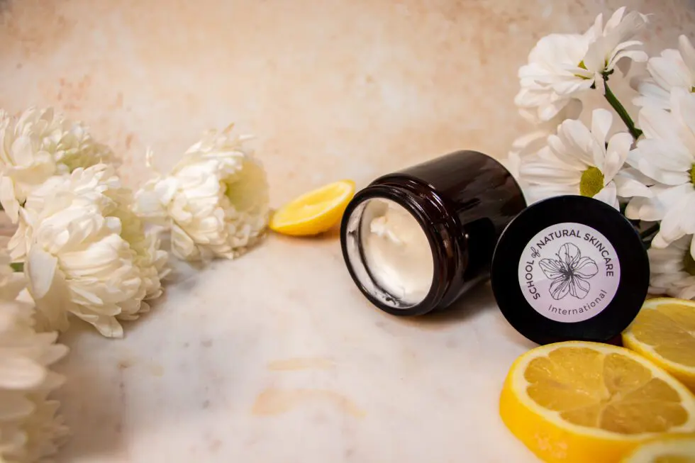 Natural skincare cream with flowers and lemon slices